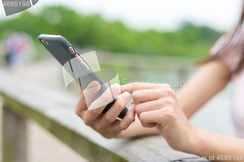 Image of Woman touch on cellphone in park