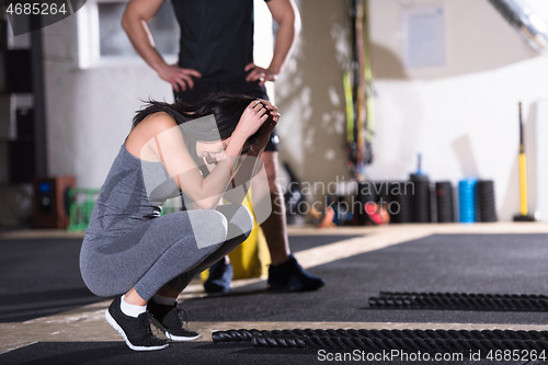 Image of sports couple doing battle ropes cross fitness exercise