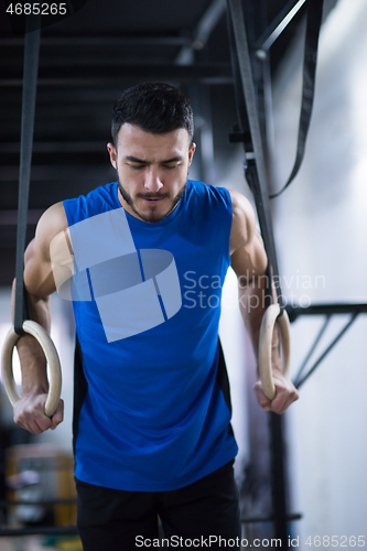 Image of man working out pull ups with gymnastic rings