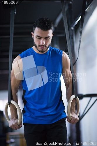 Image of man working out pull ups with gymnastic rings