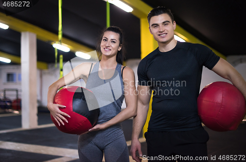 Image of young athletes couple working out with medical ball