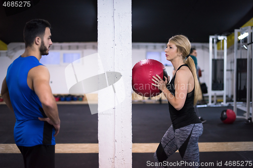 Image of young athletes couple working out with medical ball