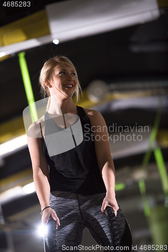 Image of athlete woman doing battle ropes cross fitness exercise