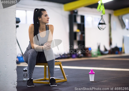 Image of young athlete woman sitting and relaxing