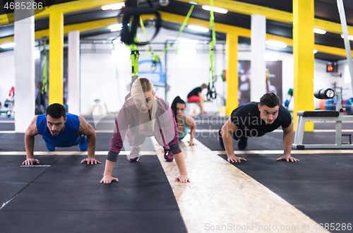 Image of young healthy people doing pushups