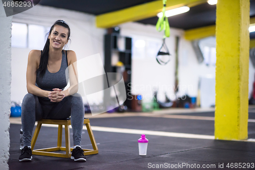 Image of young athlete woman sitting and relaxing