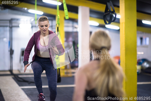 Image of athletes working out  jumping on fit box