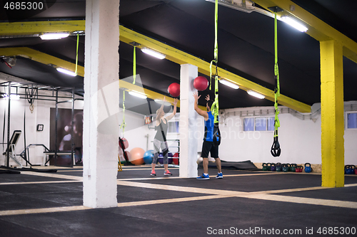 Image of young athletes couple working out with medical ball