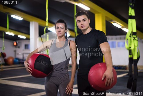 Image of young athletes couple working out with medical ball