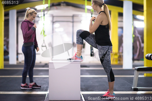 Image of athletes working out  jumping on fit box