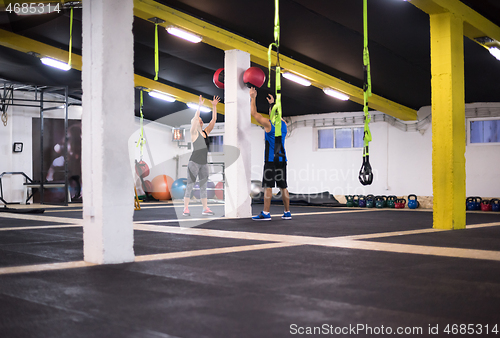 Image of young athletes couple working out with medical ball