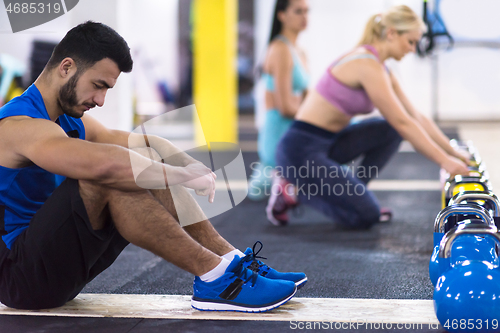 Image of young athletes doing pushups with kettlebells