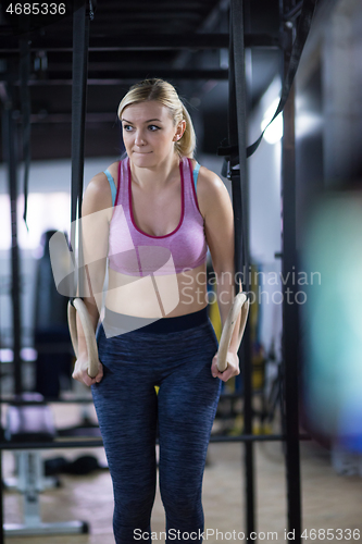 Image of woman working out pull ups with gymnastic rings