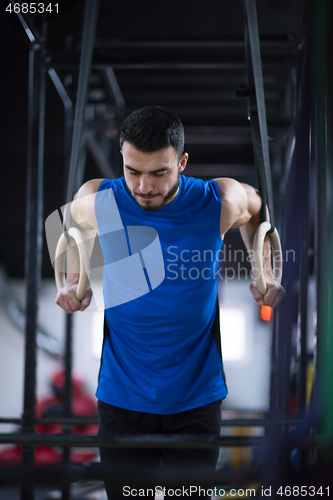 Image of man working out pull ups with gymnastic rings