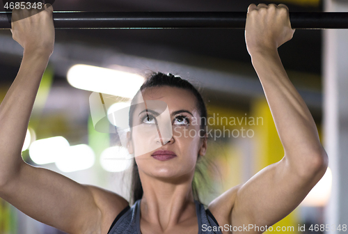 Image of woman doing pull ups on the horizontal bar