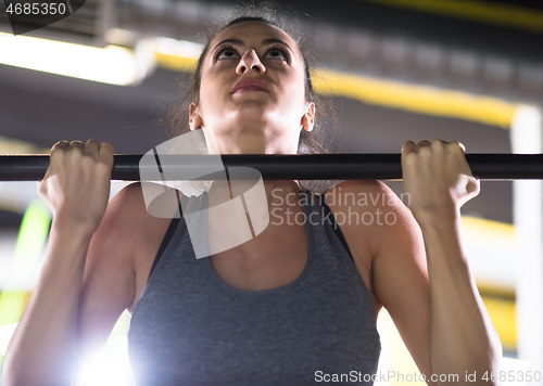 Image of woman doing pull ups on the horizontal bar