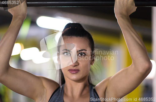 Image of woman doing pull ups on the horizontal bar