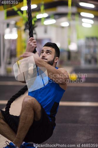 Image of man doing rope climbing