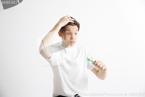 Image of Upset man looking in pregnancy test. Frustrated model