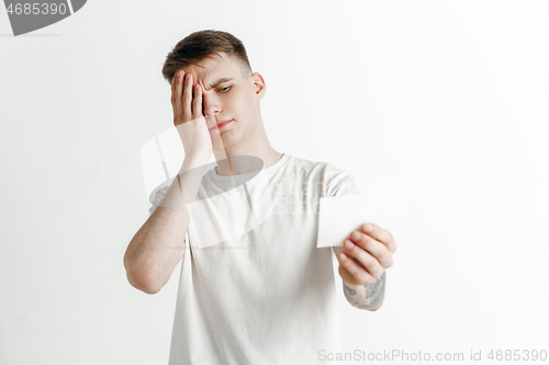 Image of Young boy with a surprised unhappy failure expression bet slip on studio background.