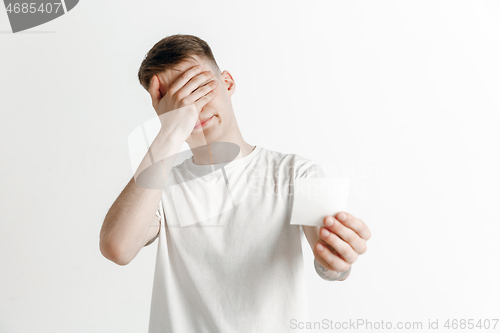 Image of Young boy with a surprised unhappy failure expression bet slip on studio background.