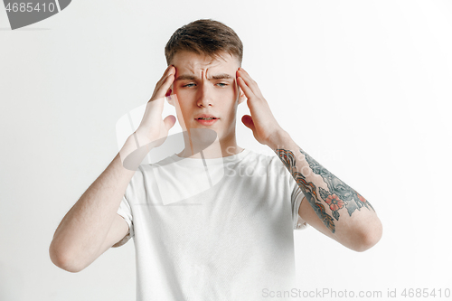 Image of Man having headache. Isolated over gray background.
