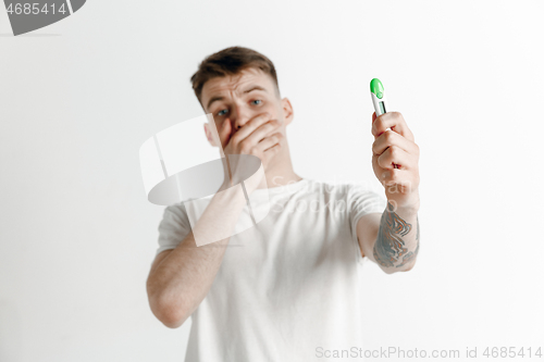 Image of Upset man looking in pregnancy test. Frustrated model