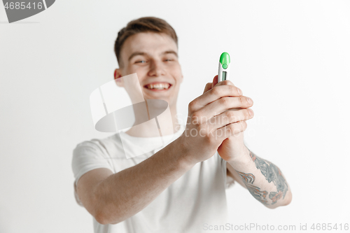 Image of Happy man looking at pregnancy test at studio