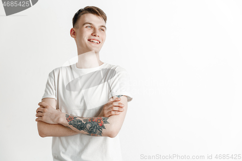 Image of The happy businessman standing and smiling against gray background.