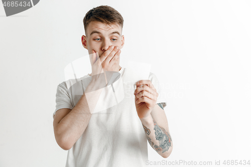 Image of Young boy with a surprised unhappy failure expression bet slip on studio background.