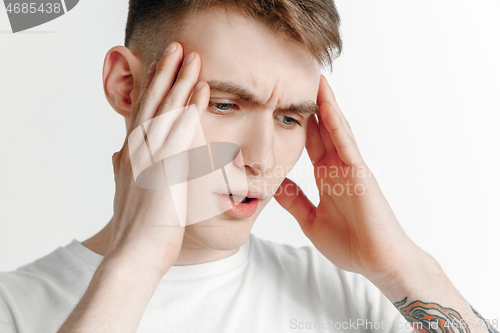 Image of Man having headache. Isolated over gray background.