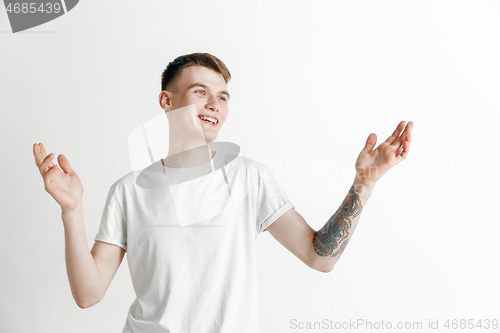 Image of The happy businessman standing and smiling against gray background.