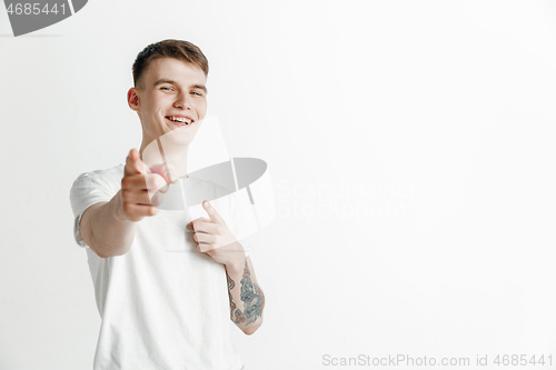 Image of The happy businessman standing and smiling against gray background.