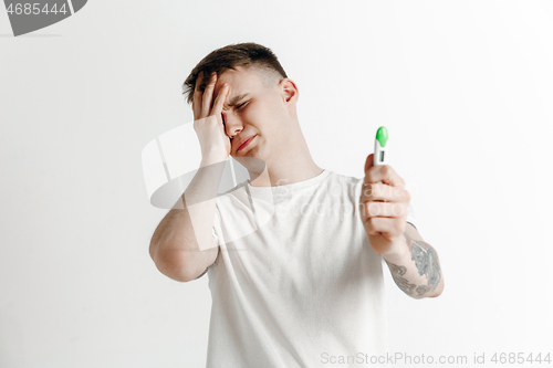 Image of Upset man looking in pregnancy test. Frustrated model