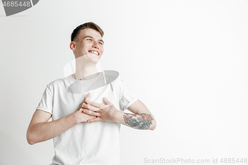 Image of The happy businessman standing and smiling against gray background.