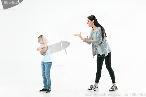 Image of Angry mother scolding her son in living room at home