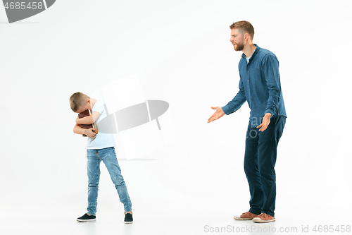 Image of Angry father scolding his son in living room at home