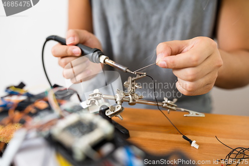 Image of Man welding the wire for assemble of drone