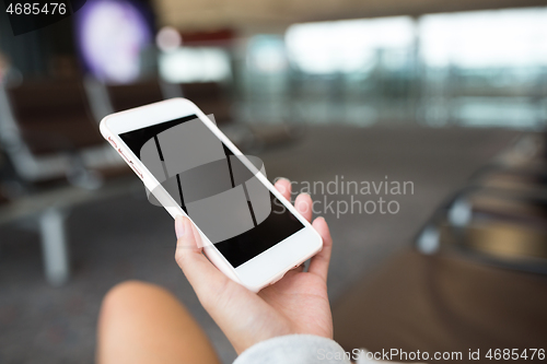 Image of Woman using cellphone in airport
