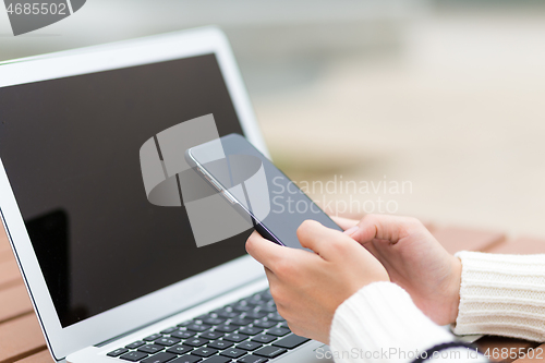 Image of Woman use of cellphone and laptop computer