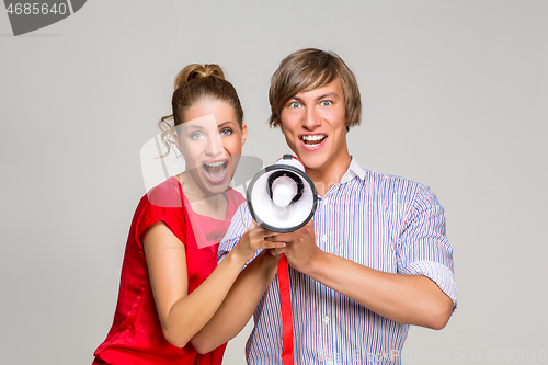 Image of young couple screaming in bullhorn