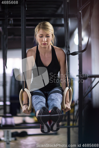 Image of woman working out pull ups with gymnastic rings