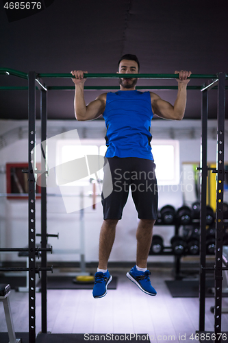 Image of man doing pull ups on the horizontal bar