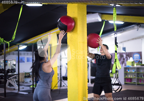 Image of young athletes couple working out with medical ball