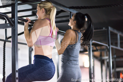 Image of young athletes doing pull ups on the horizontal bar