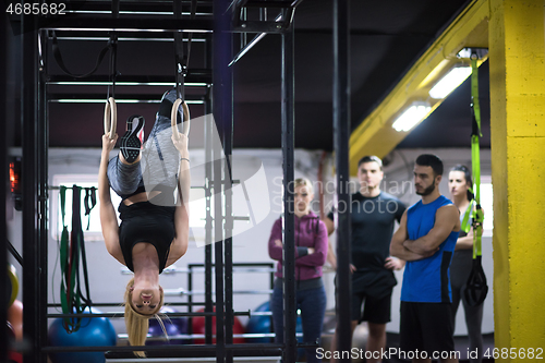 Image of woman working out with personal trainer on gymnastic rings