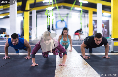 Image of young healthy people doing pushups