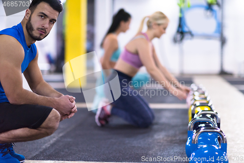 Image of young athletes doing pushups with kettlebells