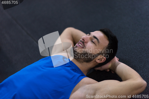 Image of young athlete man lying on the floor and relaxing