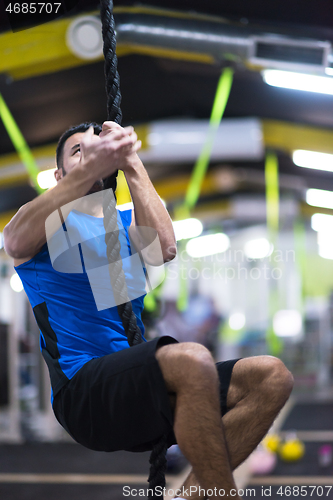 Image of man doing rope climbing